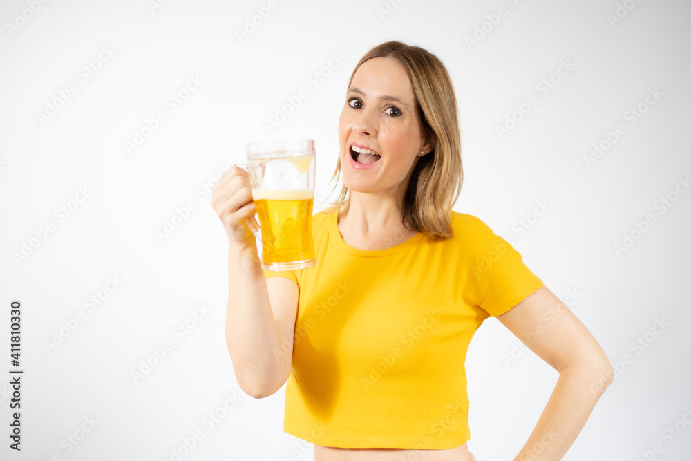 Cheerful young woman holding a beer mug full of beer and smiling over white background Cheerful young woman holding a beer mug full of beer and smiling over white background