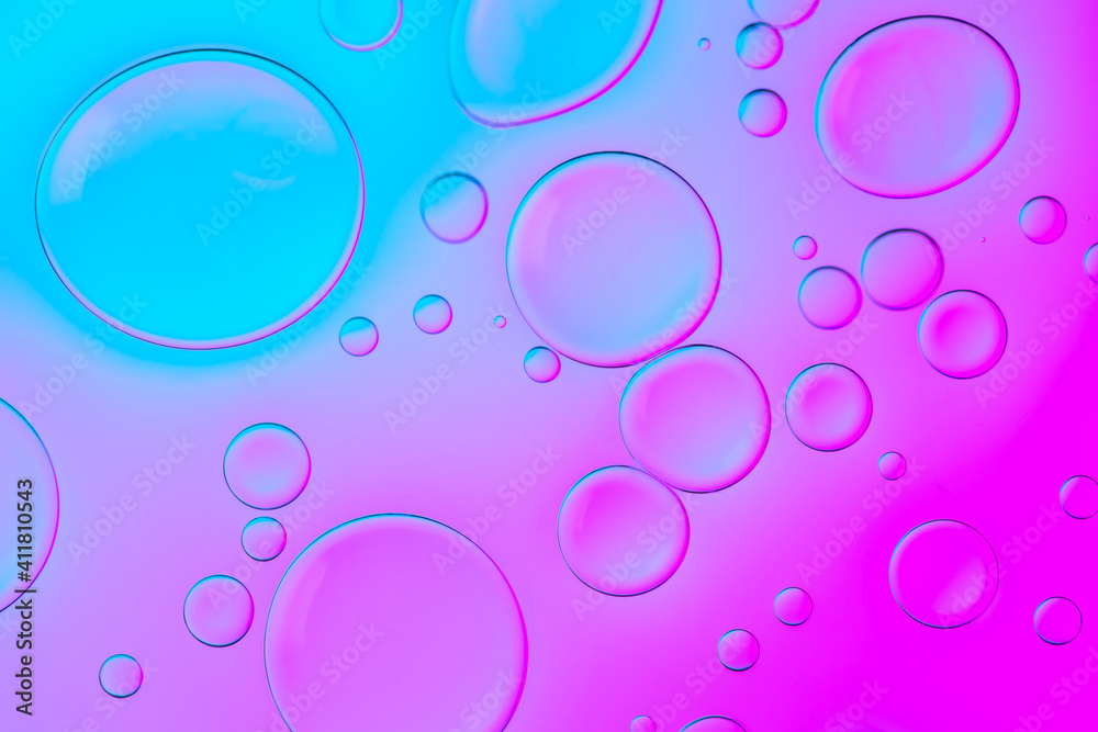 Creative neon background with drops. Glowing abstract backdrop with vibrant gradients on bubbles. Lilac, purple and blue overflowing colors
