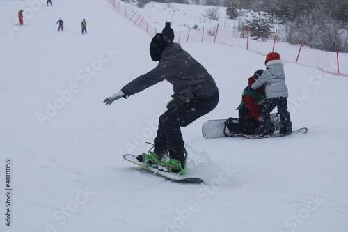 snowboarder coming down on the side of a mountain in the ski resort with the Board