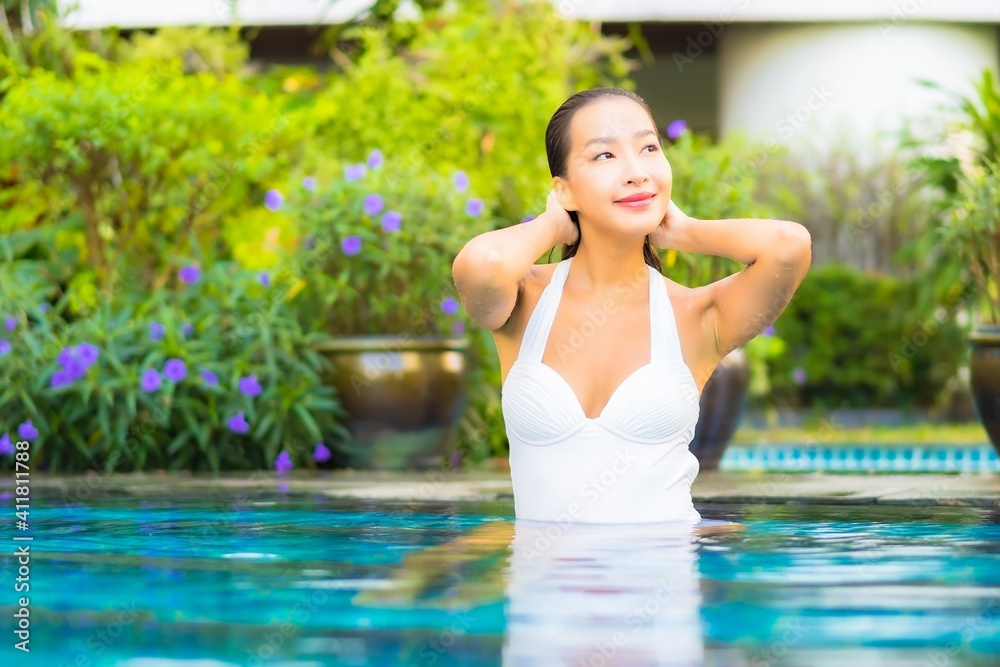 Fototapeta premium Portrait beautiful young asian woman relax smile enjoy leisure around swimming pool