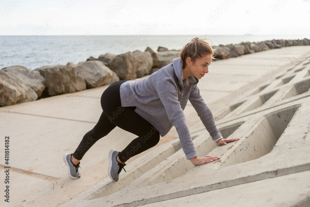 Fit woman practicing push-ups outdoors. Healthy lifestyle