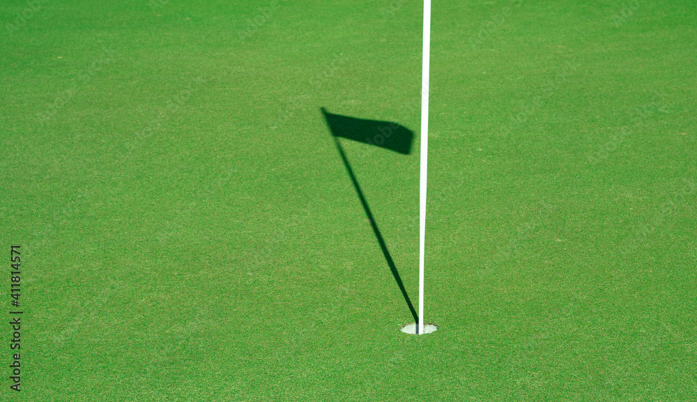 Golf hole with the shadow of the flag
