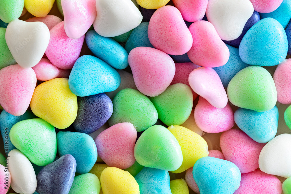 Small sweet various colourful candies in shape of heart, background, close up Small sweet various colourful candies in shape of heart, background, close up