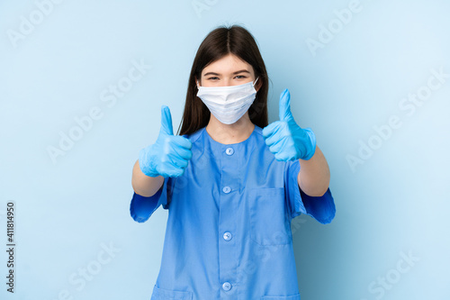 Young dentist woman holding tools over isolated blue background