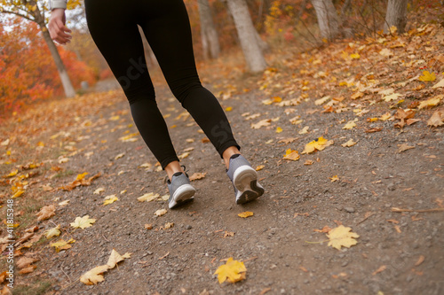 Woman runner in autumn park or forest. Healthy lifestyle, jogging