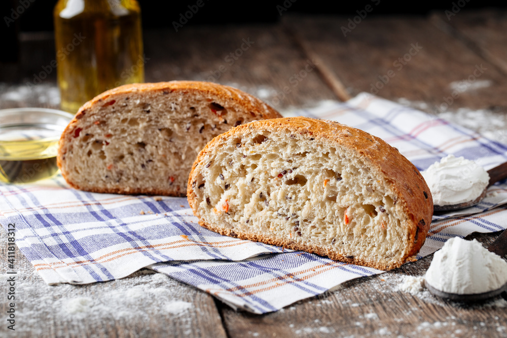 Side view on cut loaf of rustic bread with filling on the wooden table Side view on cut loaf of rustic bread with filling on the wooden table