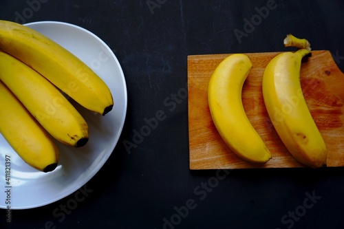 Banana in plate isolated on black background.