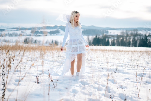 Frau in weißem Schneekleid Haute Couture Hochzeitskleid Designerkleid weiß Winterlandschaft Schnee kalt Freude lacht