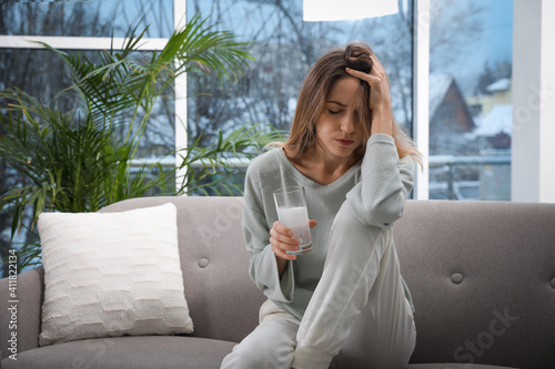 Canvas Print Woman holding glass of medicine for hangover at home