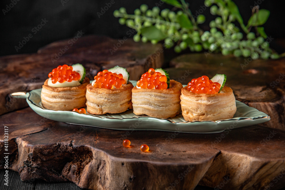 Tartlets or canapes with butter and red caviar. Gourmet food, appetizer. Delicatessen. Seafood Tartlets or canapes with butter and red caviar. Gourmet food, appetizer. Delicatessen. Seafood