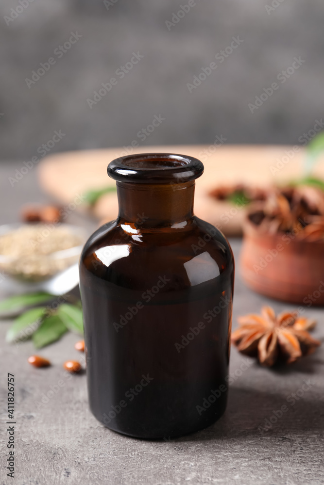 Bottle of anise essential oil on grey table Bottle of anise essential oil on grey table