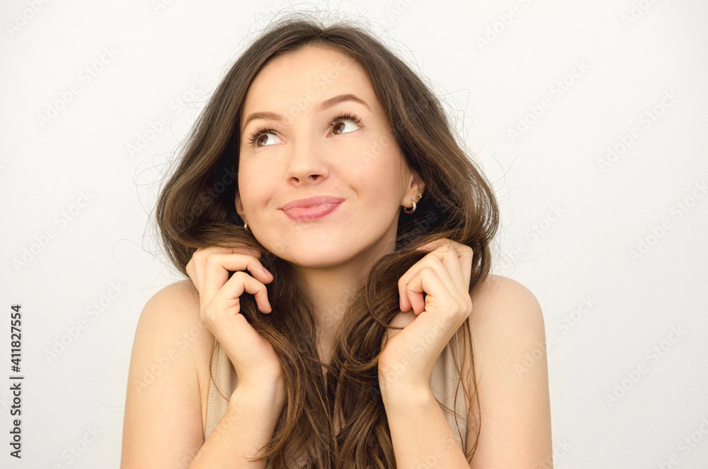 portrait of a woman holding her brown hair and smiling portrait of a woman holding her brown hair and smiling
