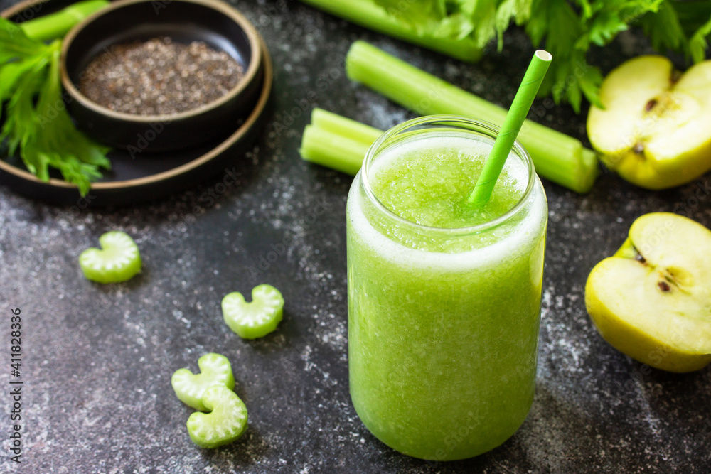 Healthy diet and nutrition, vegan, alkaline, vegetarian concept. Green smoothie with celery and apple on a dark stone countertop. Healthy diet and nutrition, vegan, alkaline, vegetarian concept. Green smoothie with celery and apple on a dark stone countertop.