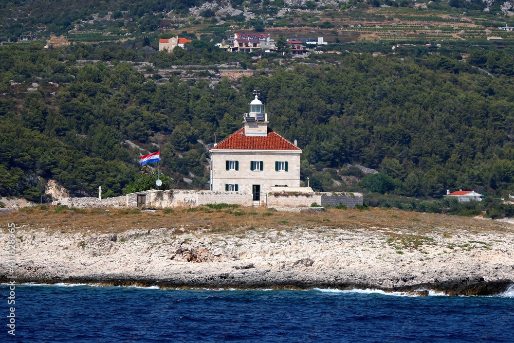 Picturesque lighthouse on small island near Hvar, Croatia. Picturesque lighthouse on small island near Hvar, Croatia.