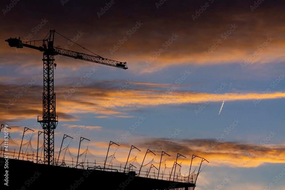 Backlight of a building and a crane at sunset