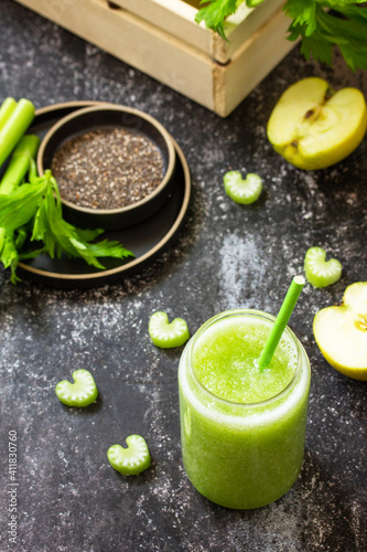Food and drink, healthy diet and nutrition, vegan, vegetarian concept. Green smoothie with celery and apple on a dark stone countertop.