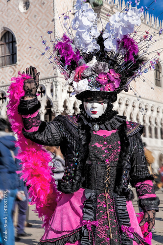 Colorful carnival masks at a traditional festival against Doge palace in Venice, Italy