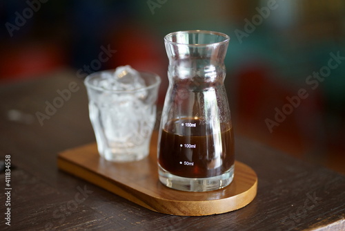  A glass of coffee and ice cubes on the table