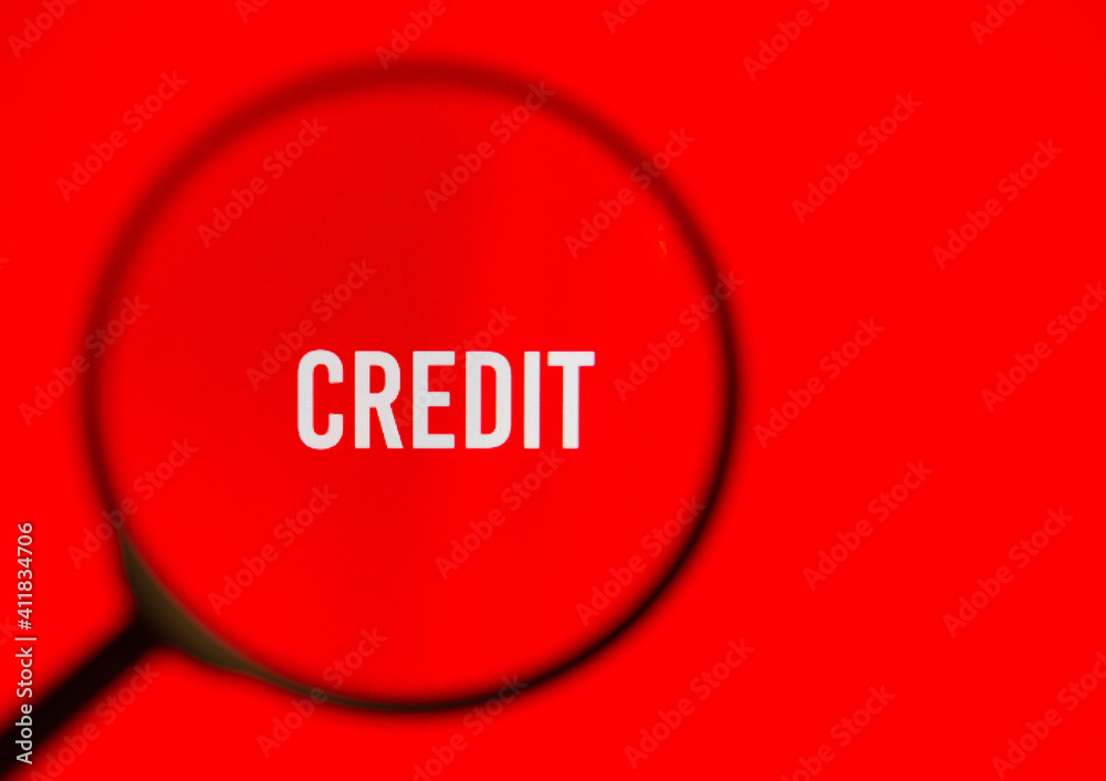 Word credit on red screen through magnifying glass. Word credit on red screen through magnifying glass.