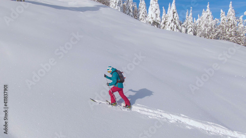 DRONE: Scenic wintry landscape surrounds a woman on a ski touring adventure