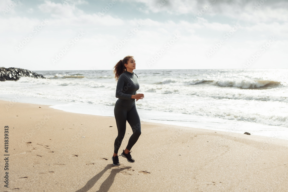 Fitness woman in sportswear running on the beach Fitness woman in sportswear running on the beach