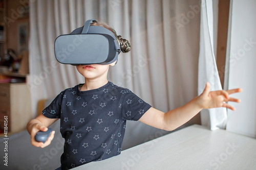 Cute girl wearing virtual reality googles at home, remote education experiment, future today, new online education, indoor lifestyle