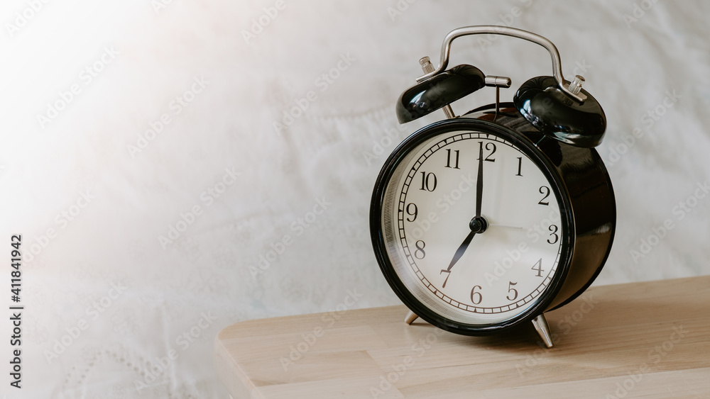 Alarm clock on wooden table with blurred background, selective focus Alarm clock on wooden table with blurred background, selective focus