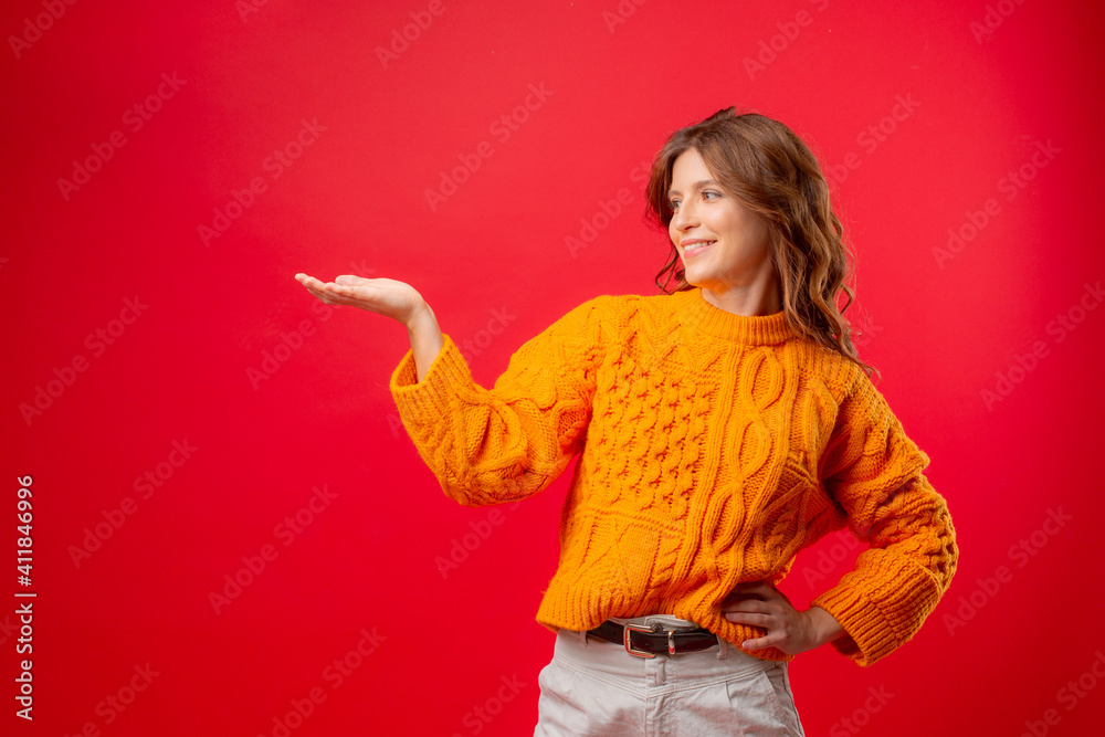 young woman on a red background of a knitted sweater shows different emotions young woman on a red background of a knitted sweater shows different emotions