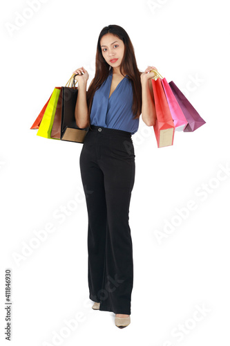 Isolated beautiful woman smiling and holding paper shopping bags on white background.