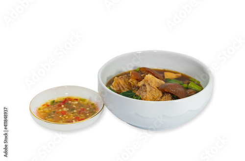 Boil pork knuckle with sour sauce in a white cup.