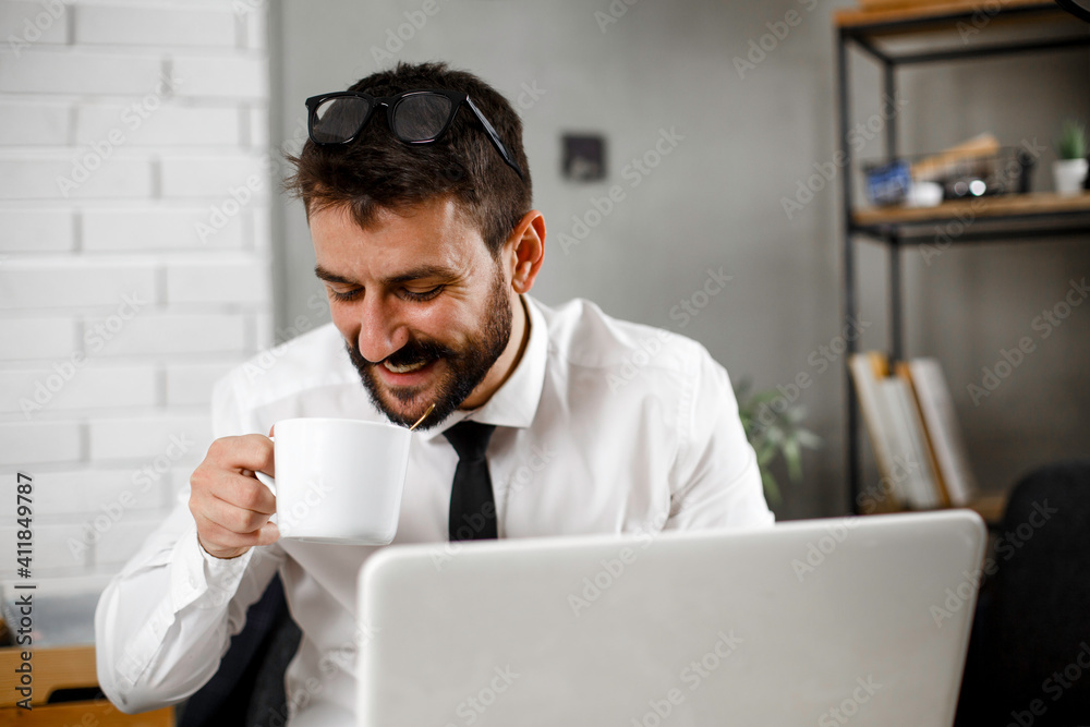 Young businessman working on laptop at office. Businessman sitting at office desk working on new project. Young businessman working on laptop at office. Businessman sitting at office desk working on new project.