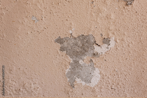 The exterior of the building has an old cement wall with paint cracks.
