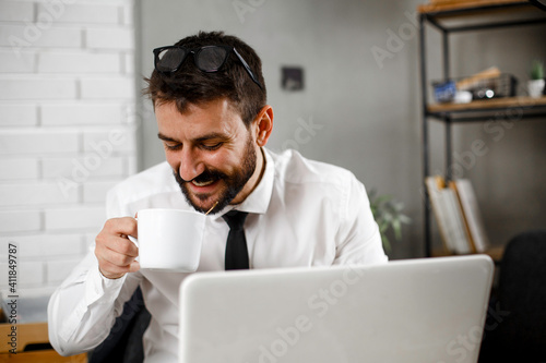 Young businessman working on laptop at office. Businessman sitting at office desk working on new project.