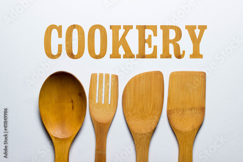 cookery. Wooden kitchen utensils on a white background, from above the inscription "cookery". Cooking concept