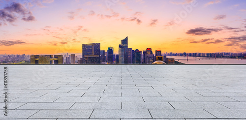 Empty square floor and modern city skyline with buildings in Hangzhou at sunset.