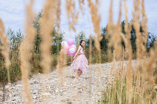 girl in the pink dress with inflatable balloons