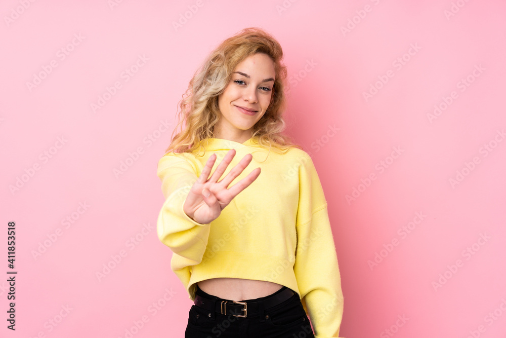Young blonde woman wearing a sweatshirt isolated on pink background happy and counting four with fingers Young blonde woman wearing a sweatshirt isolated on pink background happy and counting four with fingers