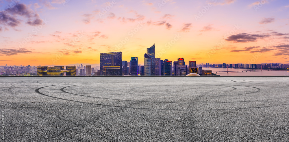 Race track road and modern city skyline with buildings in Hangzhou at sunset.