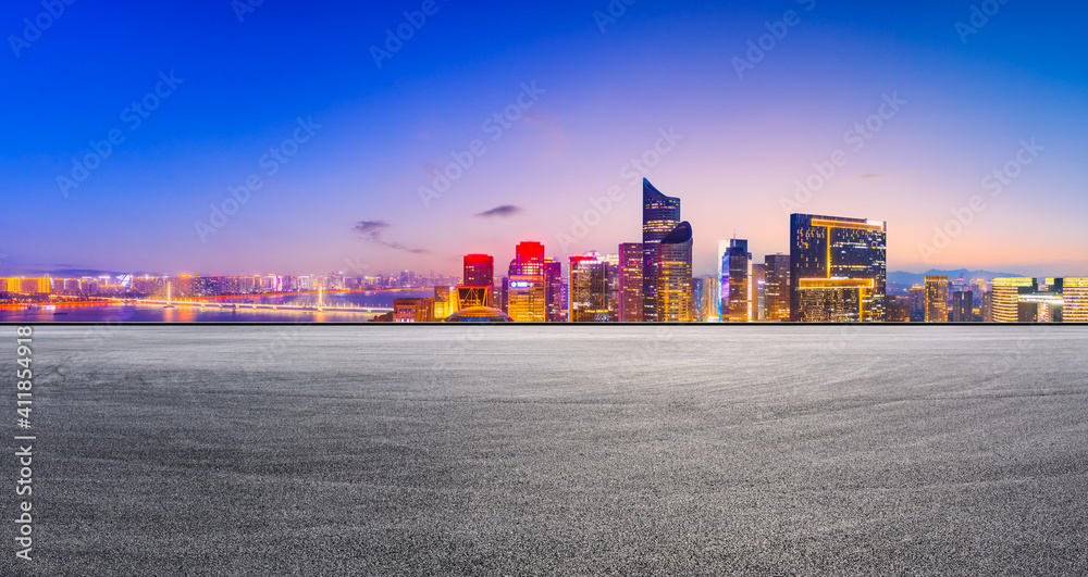 Race track road and modern city skyline with buildings in Hangzhou at night.