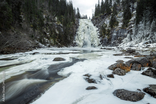 Frozen waterfall in Norwegian forest. Homla river in Norway.