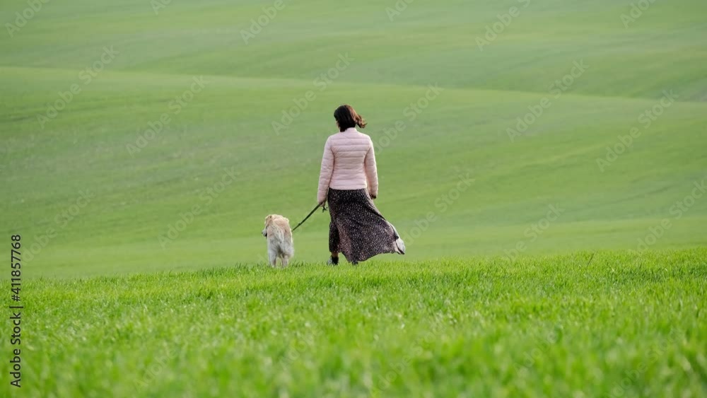 Pretty woman walking with golden retriever outdoors in spring Pretty woman walking with golden retriever outdoors in spring