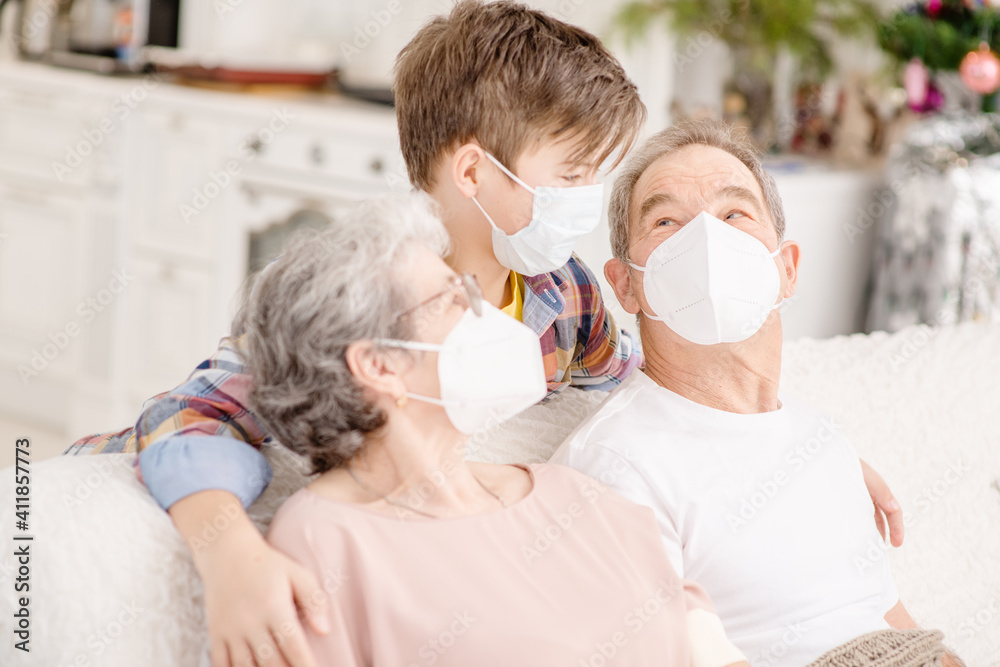 Portrait of a family during the coronavirus pandemic. Old people in medical masks communicate with a child at home