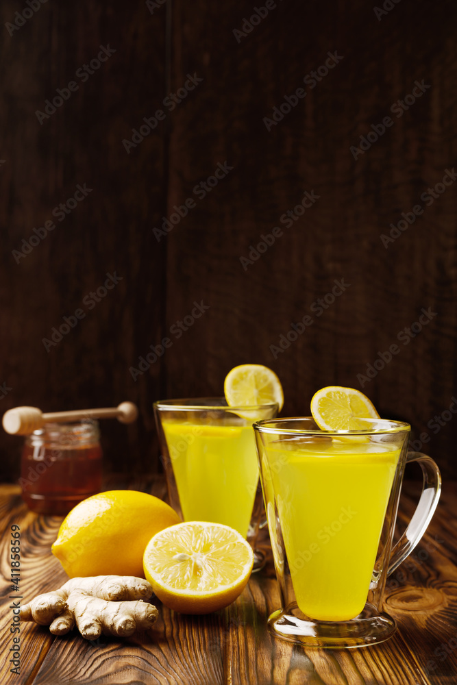 Fototapeta premium Glass cups of lemon ginger lemonade and ingredients vertical shot with copy space