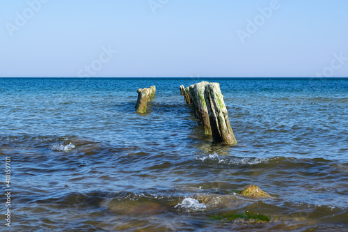 Wooden breakwaters line at Baltic Sea. © Максим Якимов