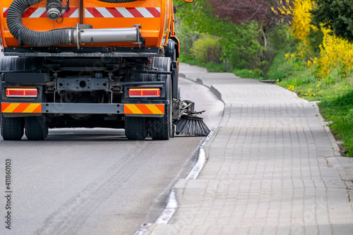 Sweeper is cleaning empty road.