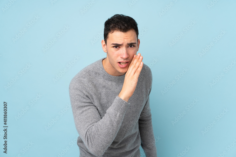 Young caucasian handsome man isolated on blue background whispering something Young caucasian handsome man isolated on blue background whispering something
