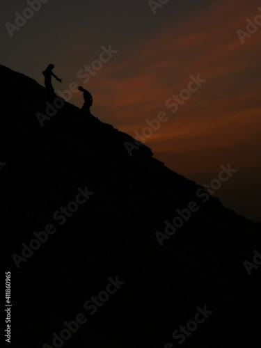 a man helping another man to climb