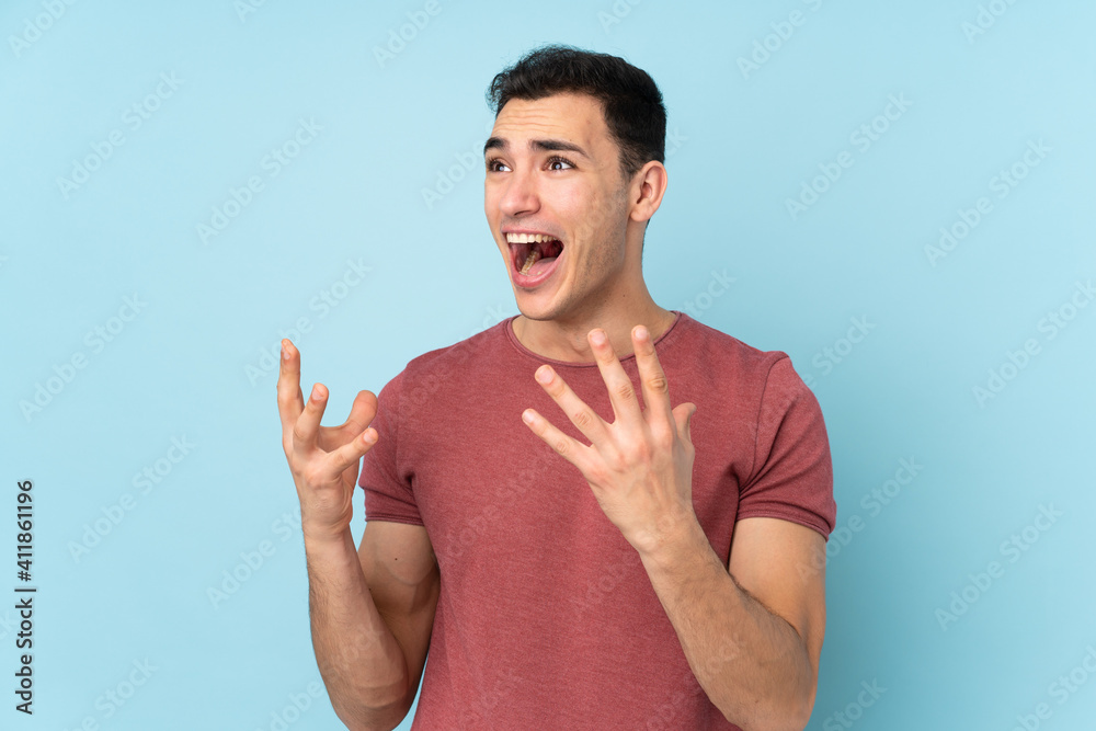 Young caucasian handsome man isolated on blue background with surprise facial expression Young caucasian handsome man isolated on blue background with surprise facial expression