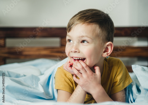 cheerful and surprised child lies on the bed