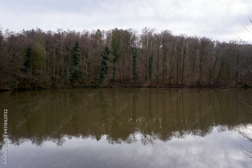 Beautiful view of a calm lake with reflection of trees in the water Beautiful view of a calm lake with reflection of trees in the water